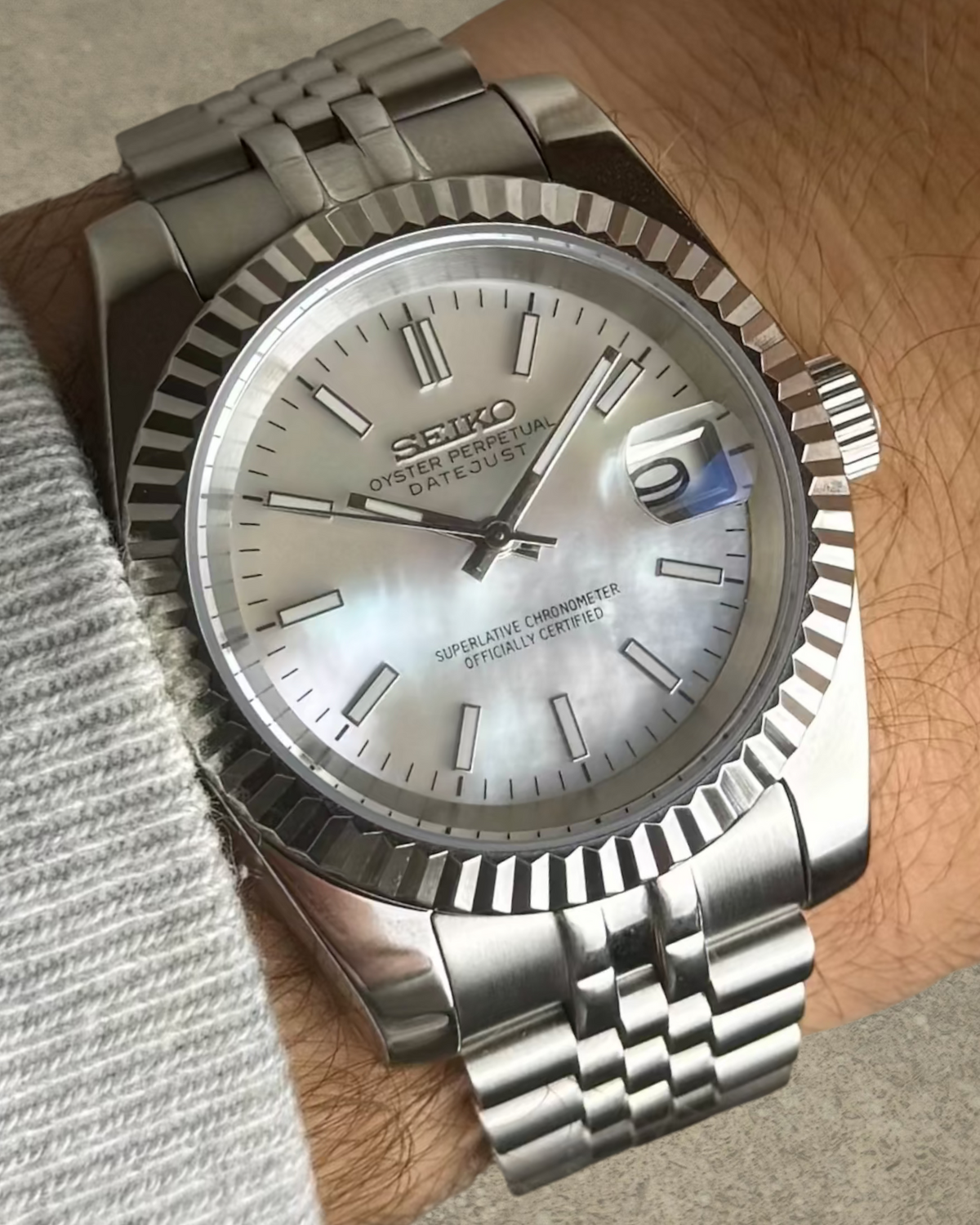 PB TimePiece Classic Date watch with mother of pearl dial, fluted bezel, and stainless steel jubilee bracelet on wrist