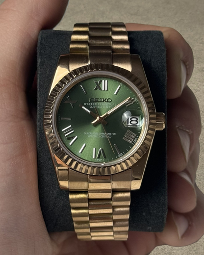 PB TimePiece Classic Date watch with an olive green dial, rose gold stainless steel case, fluted bezel, and bracelet.