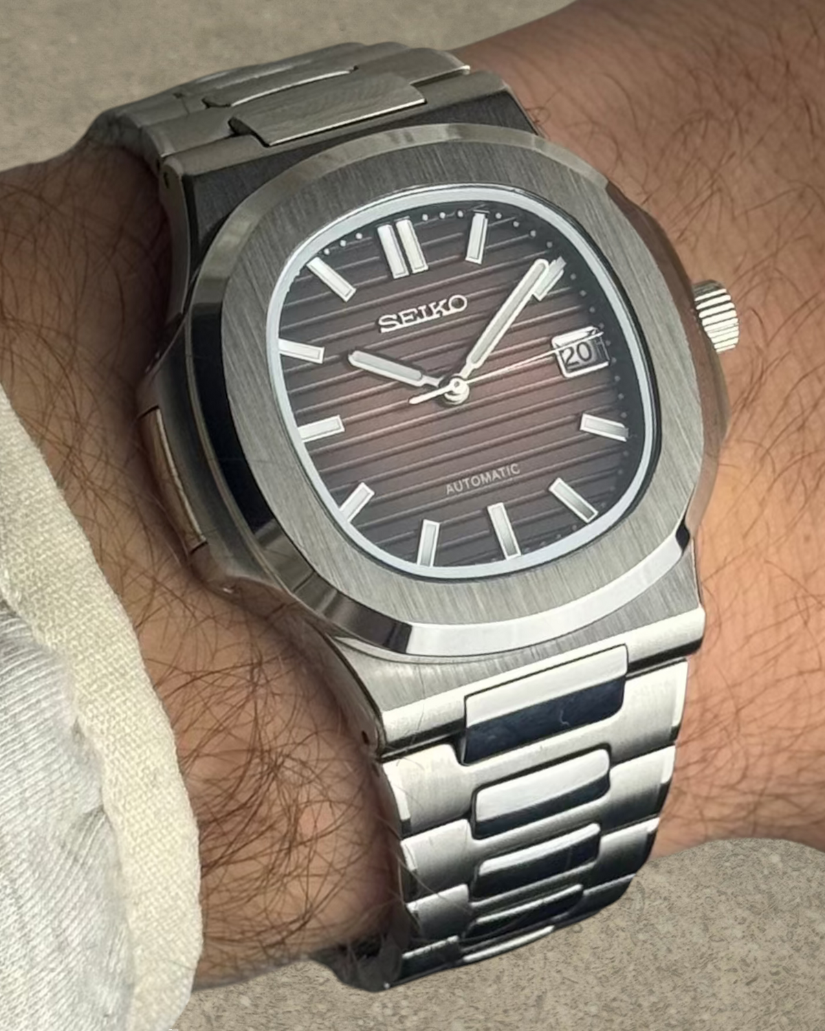 PB TimePiece Novara watch with a textured ombre brown dial, stainless steel case, and bracelet on a wrist.