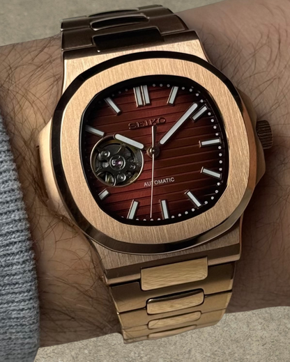PB TimePiece Novara rose gold automatic watch with an open heart chocolate dial and stainless steel bracelet.