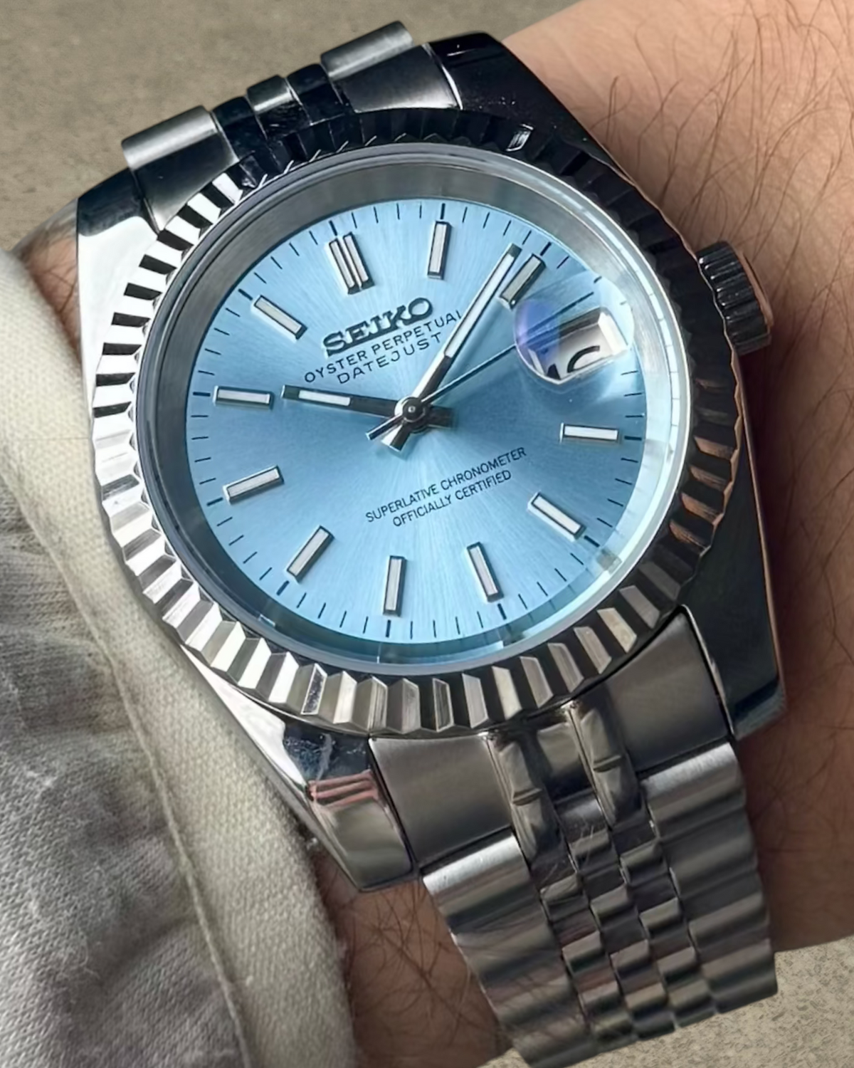 PB TimePiece Classic Date watch with ice blue dial, fluted bezel, and stainless steel jubilee bracelet on wrist
