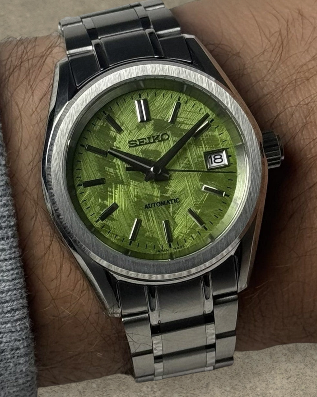 PB TimePiece Heritage watch with a pistachio green textured dial, stainless steel case, and bracelet on a wrist.