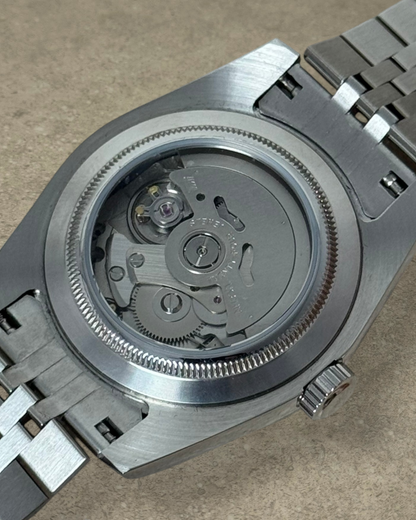 PB TimePiece Classic Date watch showing the exhibition case back with automatic Seiko NH35 movement and steel bracelet