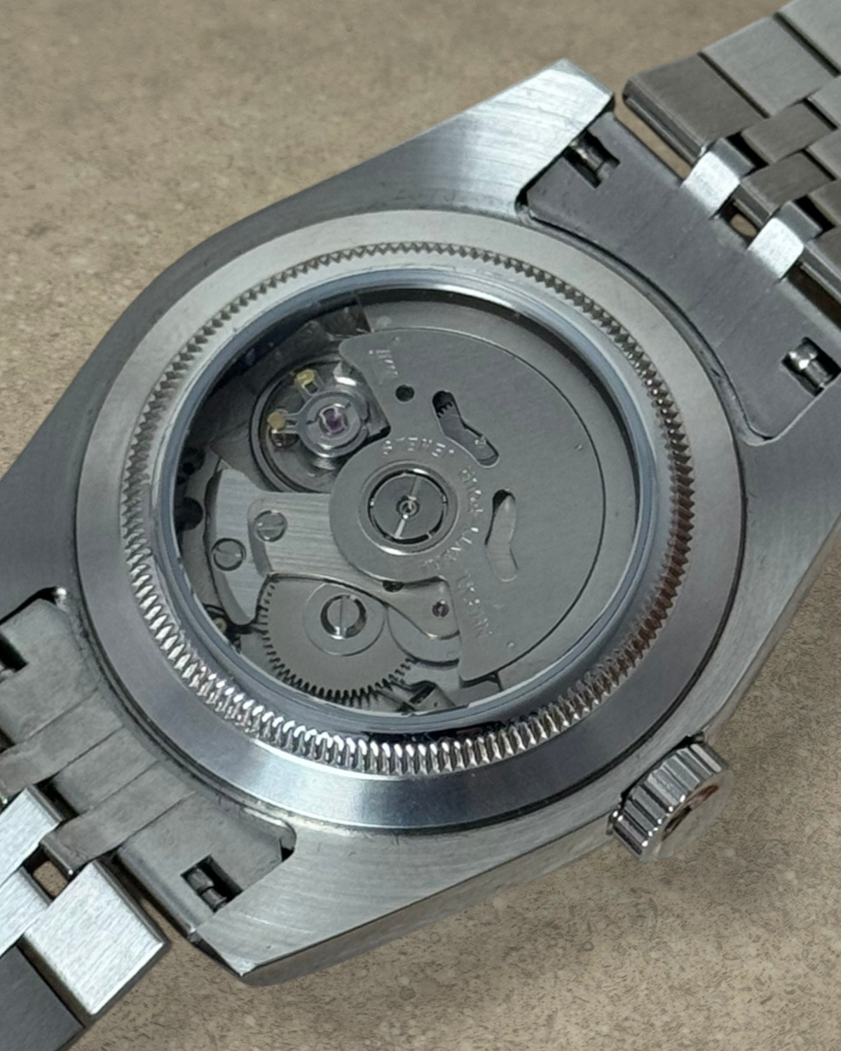 PB TimePiece Classic Date watch showing the exhibition case back with Seiko NH35 automatic movement and steel bracelet