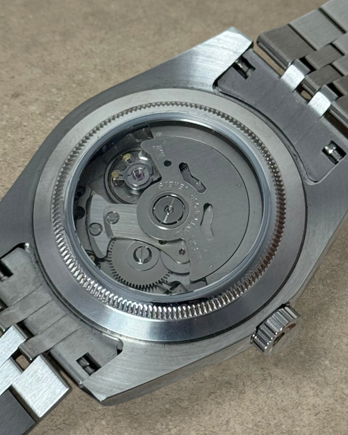 PB TimePiece Classic Date watch showing the exhibition case back with automatic Seiko NH35 movement and jubilee band