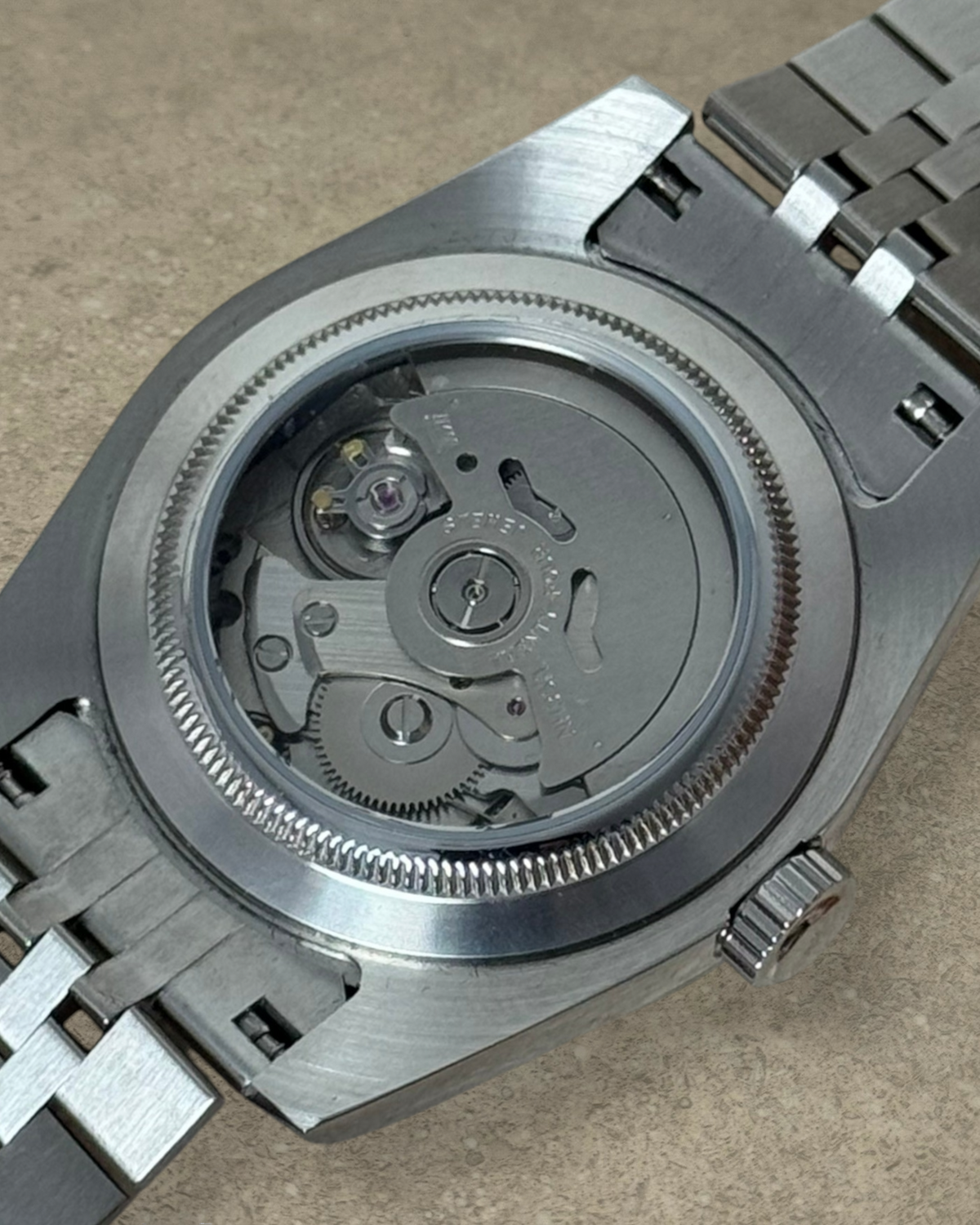 PB TimePiece Classic Date watch showing the exhibition case back with Seiko NH35 automatic movement and steel bracelet