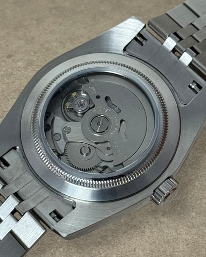 PB TimePiece Classic Date watch showing the exhibition case back with Seiko NH35 automatic movement and steel bracelet