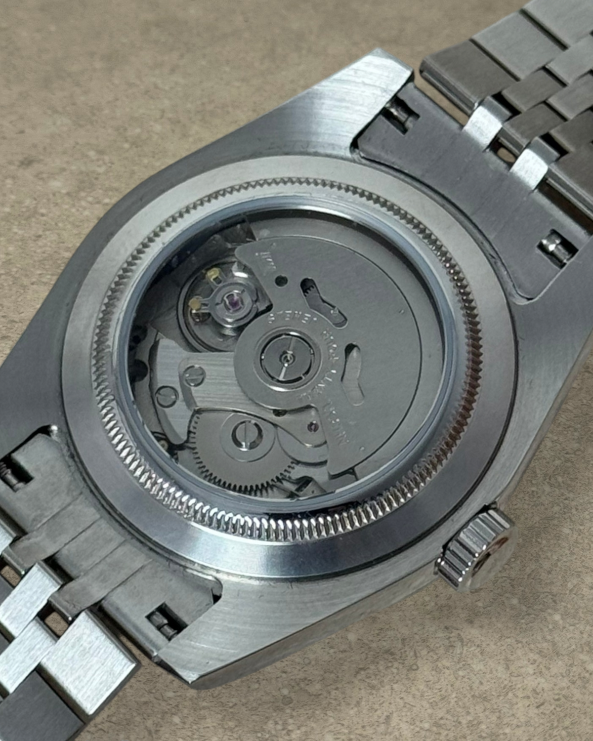 PB TimePiece Classic Date watch showing the exhibition case back with automatic Seiko NH35 movement and jubilee band.