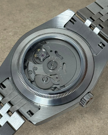 PB TimePiece Classic Date watch showing the exhibition case back with automatic Seiko NH35 movement and jubilee band.