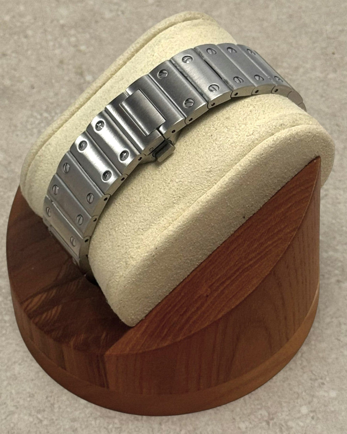 PB TimePiece Aviator watch featuring a stainless steel bracelet with a butterfly clasp on a wooden display stand