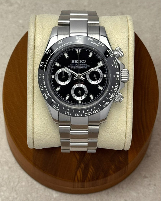 PB TimePiece black chronograph watch with stainless steel 39mm case, black bezel, and polished oyster bracelet.