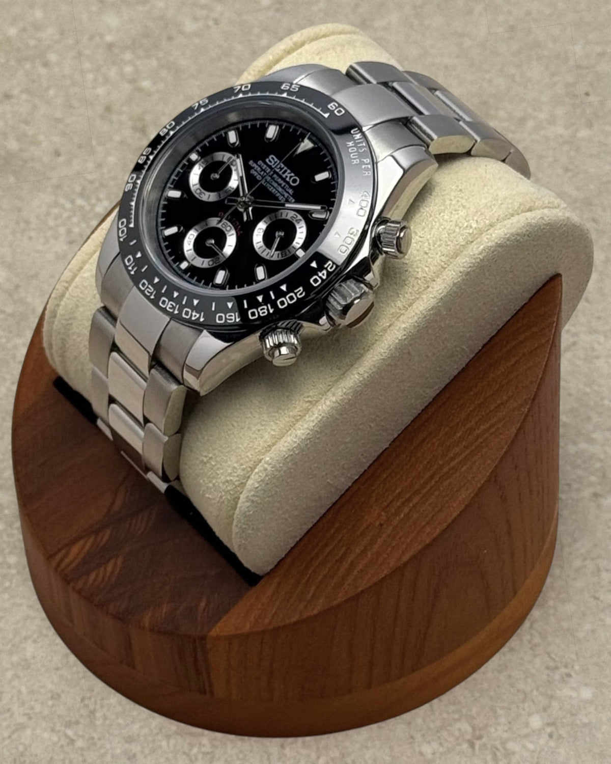 PB TimePiece black chronograph watch with stainless steel oyster bracelet and sapphire crystal on a wooden stand