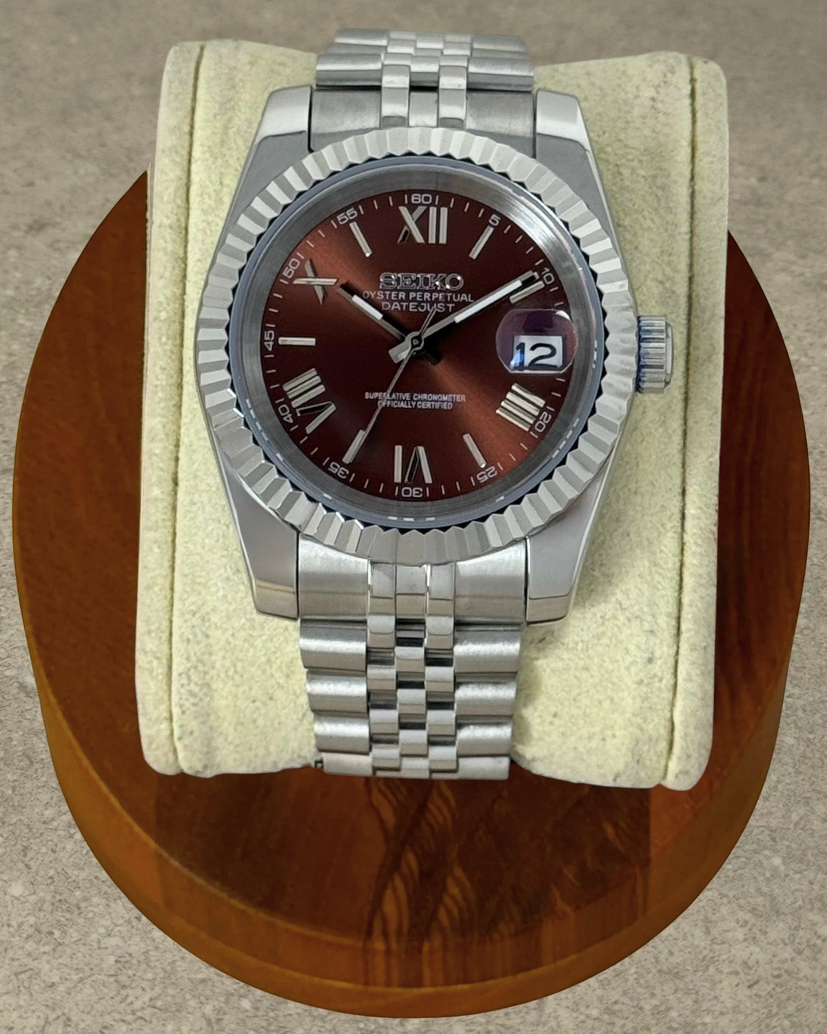 PB TimePiece Classic Date watch with a chocolate dial, Roman numerals, fluted bezel, and stainless steel bracelet.