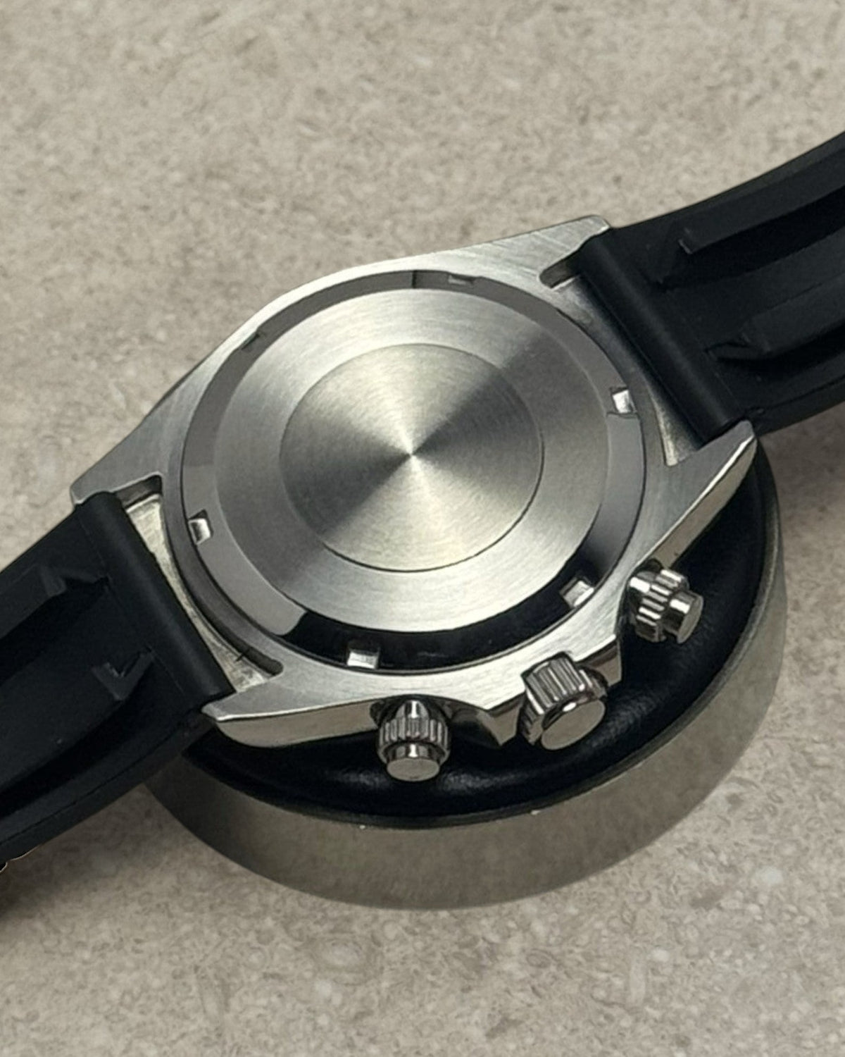 PB TimePiece chronograph watch back case showing stainless steel finish and black rubber strap attachment