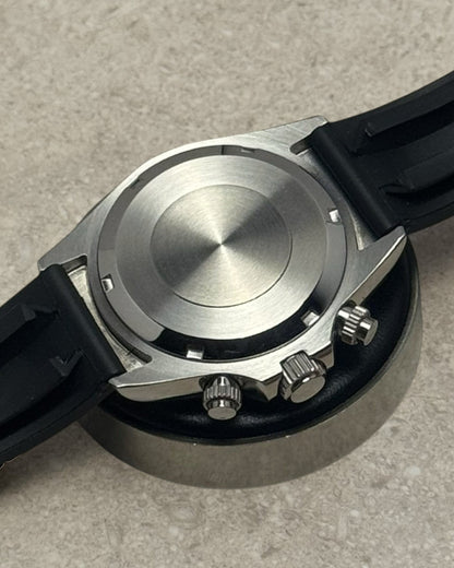 PB TimePiece chronograph watch back case showing stainless steel finish and black rubber strap attachment