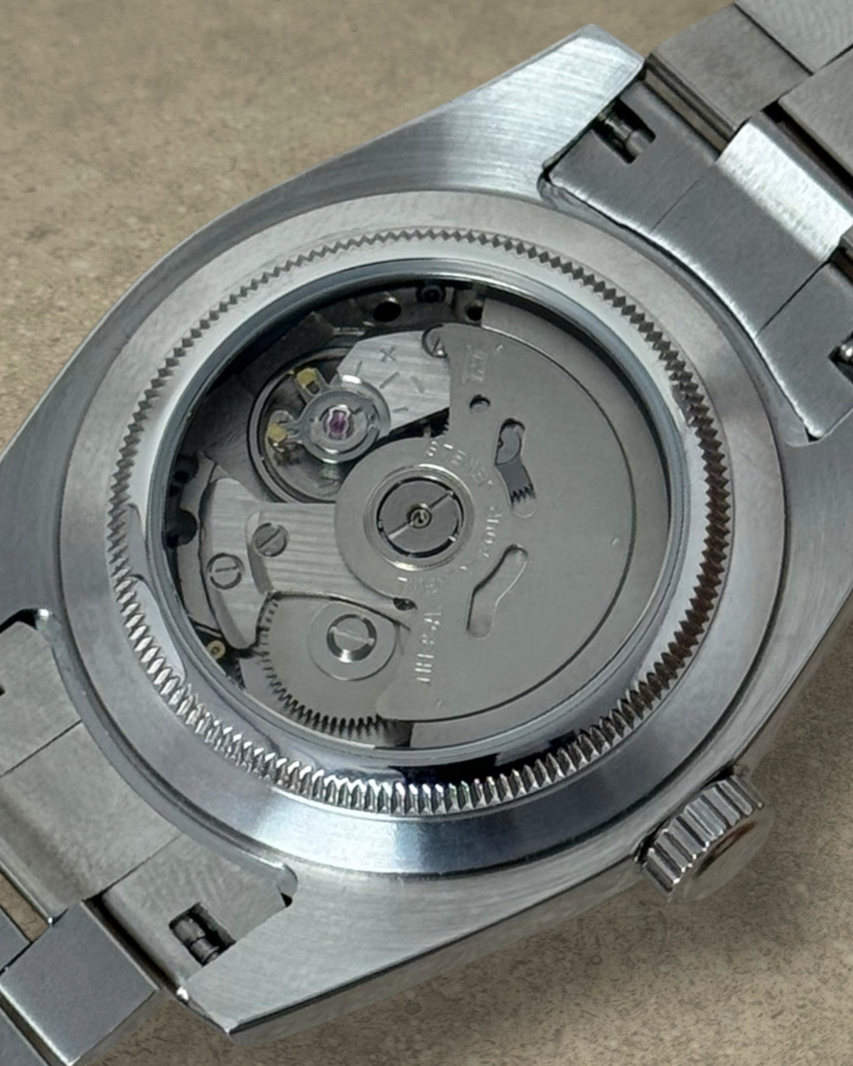PB TimePiece Classic Date watch showing the exhibition case back with Seiko NH35 automatic movement and steel bracelet
