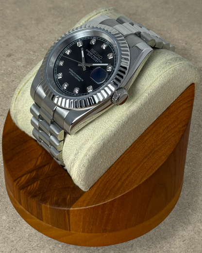 PB TimePiece Classic Date watch with a black dial, crystal markers, fluted bezel, and stainless steel bracelet.
