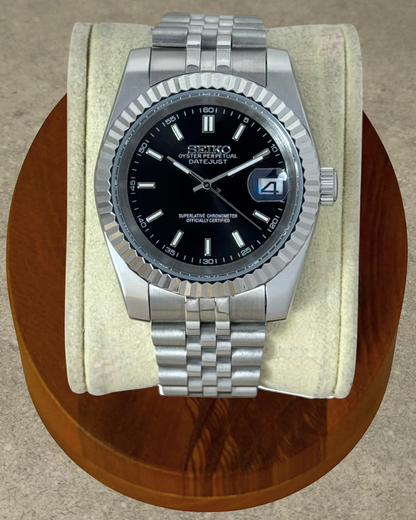 PB TimePiece Classic Date watch with a black dial, fluted bezel, and stainless steel jubilee bracelet.