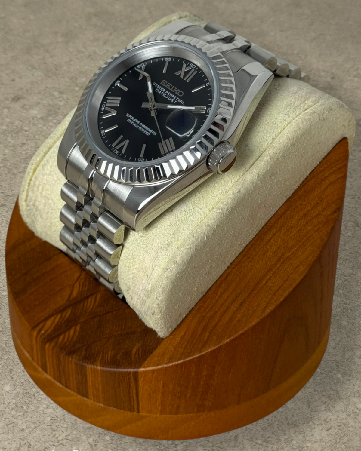 PB TimePiece Classic Date watch with a jet black dial, Roman numerals, fluted bezel, and stainless steel bracelet.