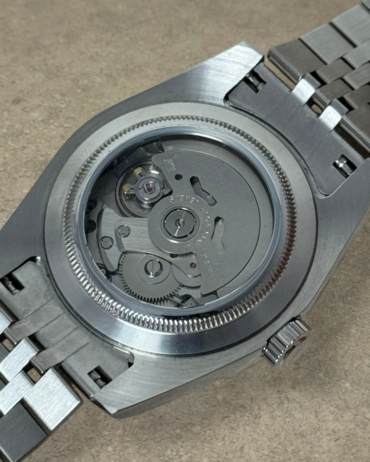 PB TimePiece Classic Date watch showing the exhibition case back with automatic Seiko NH35 movement and jubilee band