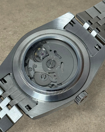 PB TimePiece Classic Date watch showing the exhibition case back with automatic Seiko NH35 movement and jubilee band