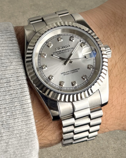 PB TimePiece Classic Date watch with silver dial, crystal markers, fluted bezel, and stainless steel bracelet on wrist