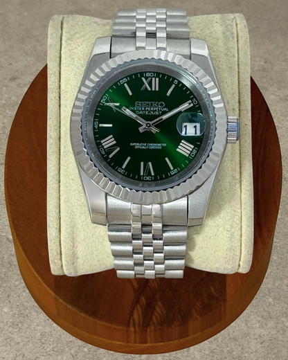 PB TimePiece Classic Date watch with emerald green dial, Roman numerals, fluted bezel, and stainless steel bracelet.