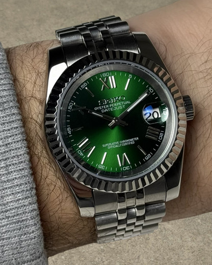 PB TimePiece Classic Date watch with emerald green dial, Roman numerals, fluted bezel, and stainless steel bracelet.
