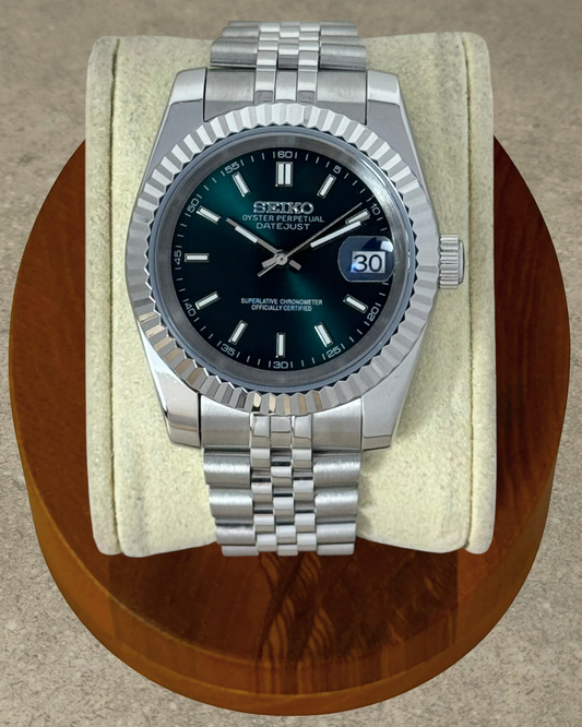 PB TimePiece Classic Date watch with a forest green dial, stainless steel jubilee bracelet, and fluted bezel.