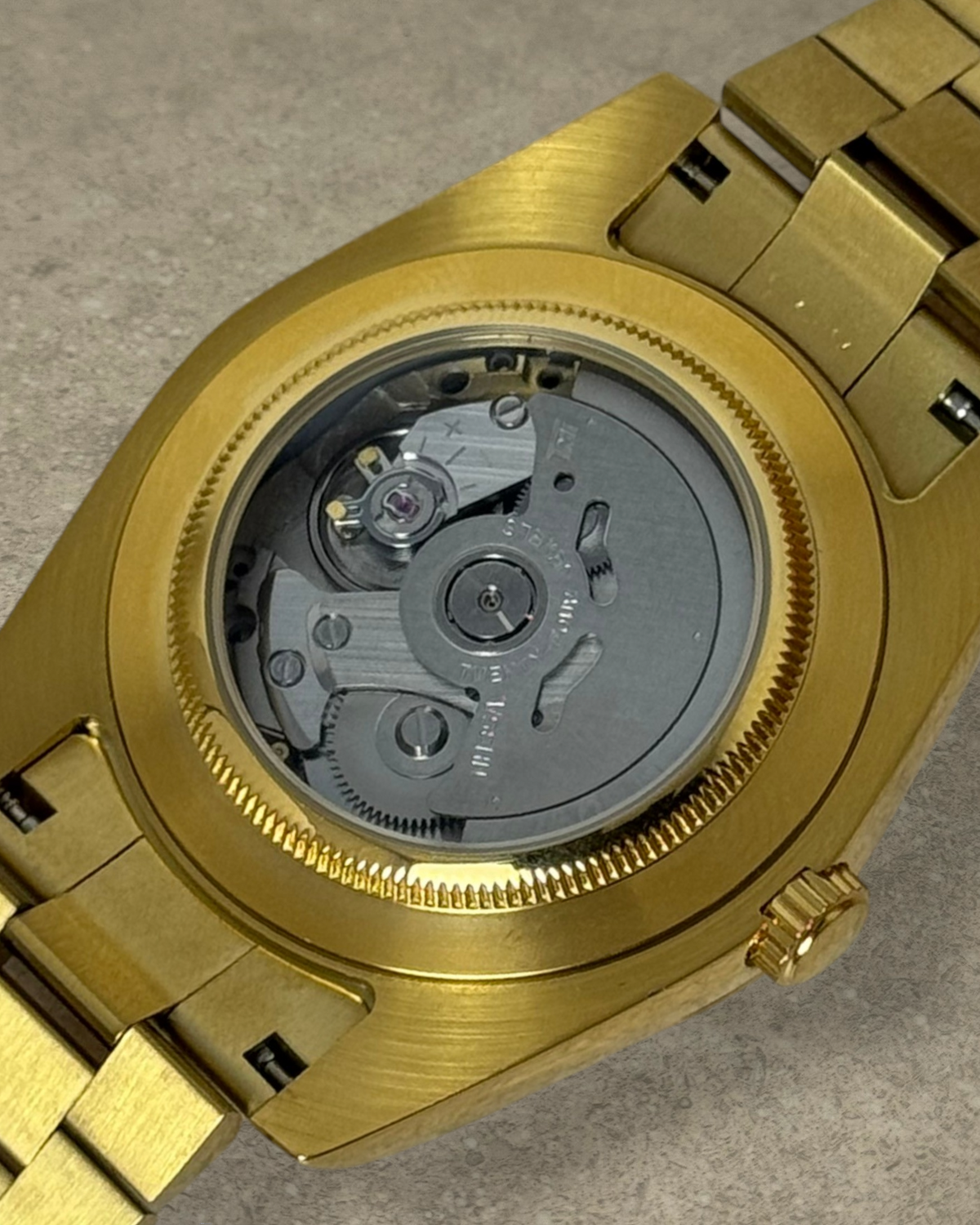 PB TimePiece Classic Date gold watch showing the automatic Seiko NH35 movement through the exhibition case back.