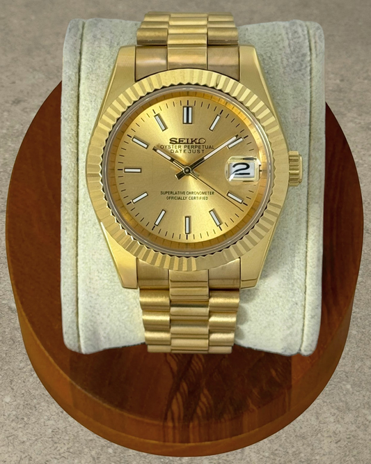 PB TimePiece Classic Date watch with gold stainless steel case, fluted bezel, champagne dial, and presidential band.