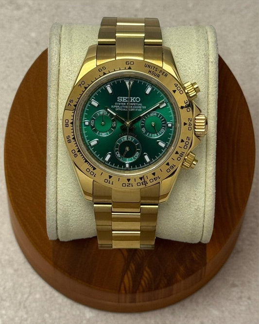PB TimePiece John Mayer chronograph watch with a gold 39mm case, green dial, and polished gold oyster bracelet.