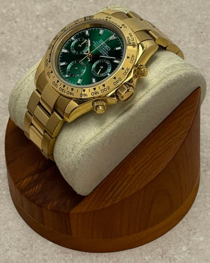 PB TimePiece John Mayer chronograph watch with a 39mm gold case, green dial, and polished gold oyster bracelet.