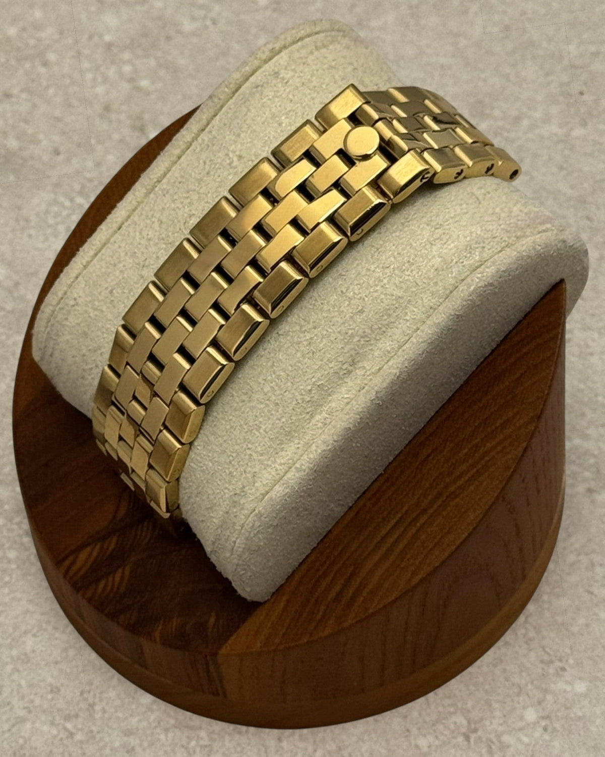PB TimePiece Honeycomb gold watch featuring a flat jubilee bracelet with a hidden clasp on a display stand