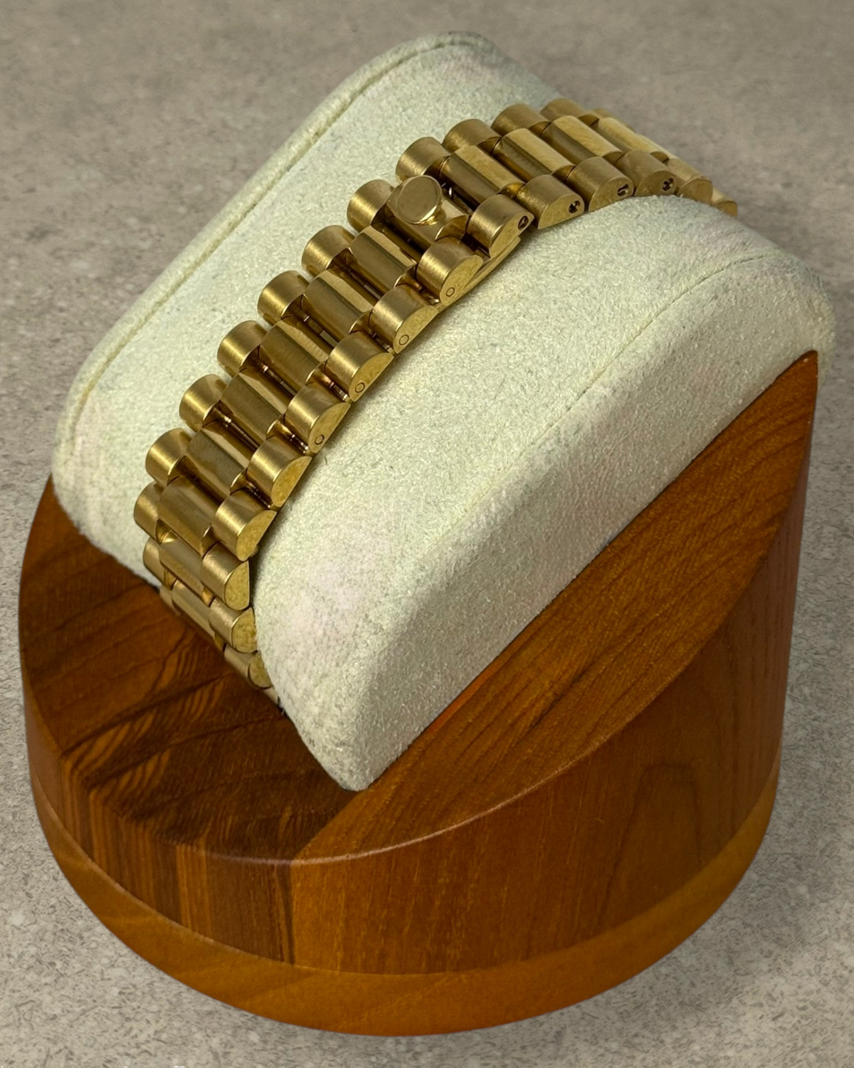 PB TimePiece Classic Date gold stainless steel presidential bracelet with hidden clasp on a display stand