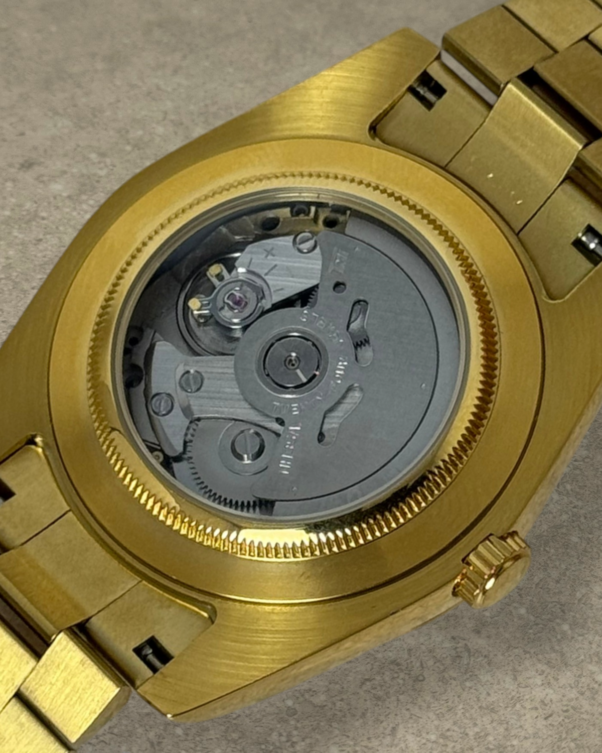 PB TimePiece Classic Date watch showing the gold stainless steel case back with an exposed Seiko NH35 movement