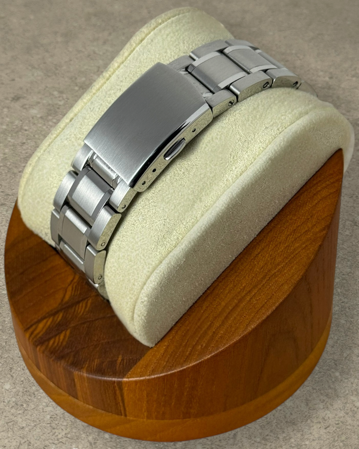 PB TimePiece Heritage watch stainless steel bracelet with milled folding clasp on a wooden display stand