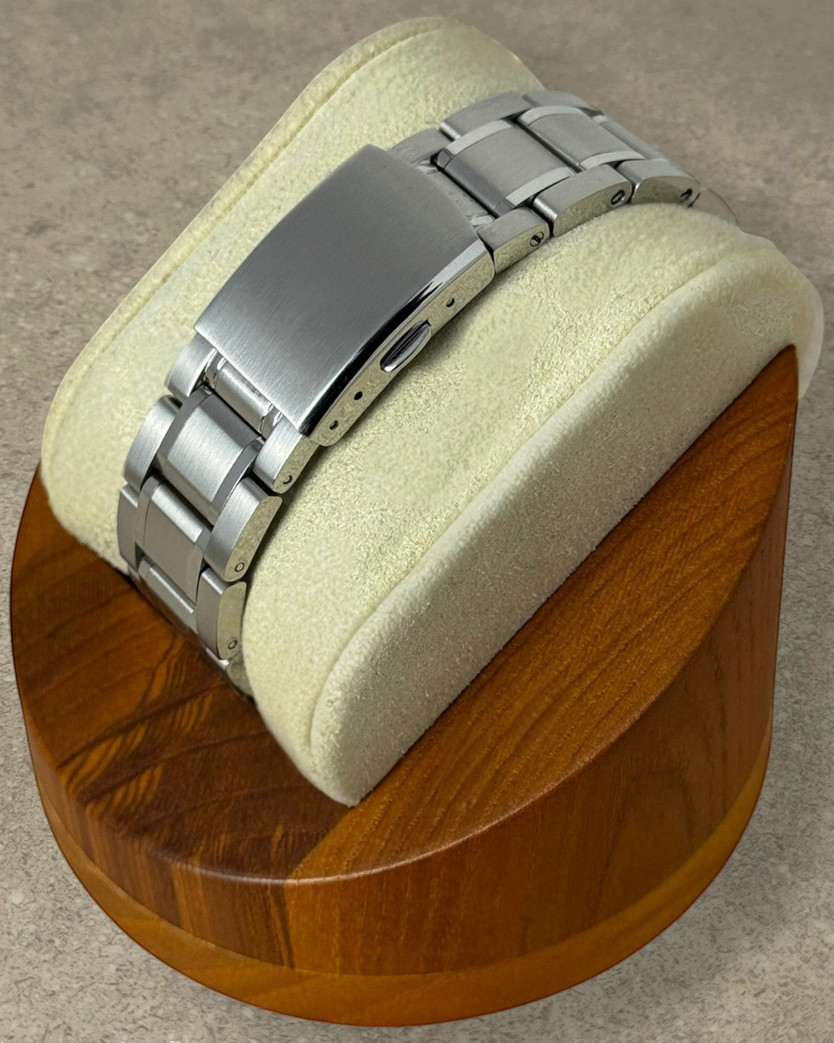PB TimePiece Heritage watch stainless steel bracelet with milled folding clasp on a wooden display stand