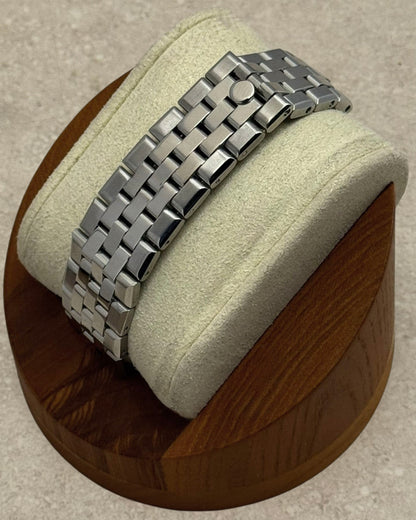 PB TimePiece Honeycomb watch featuring a stainless steel jubilee bracelet with a hidden clasp on a wooden display