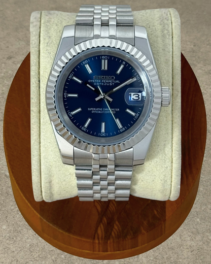 PB TimePiece Classic Date watch with navy blue dial, stainless steel jubilee bracelet, and fluted bezel.