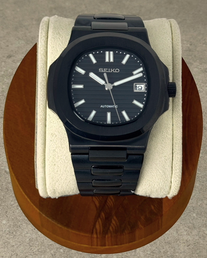 PB TimePiece Novara watch featuring a black stainless steel case, textured black dial, and matching black bracelet.
