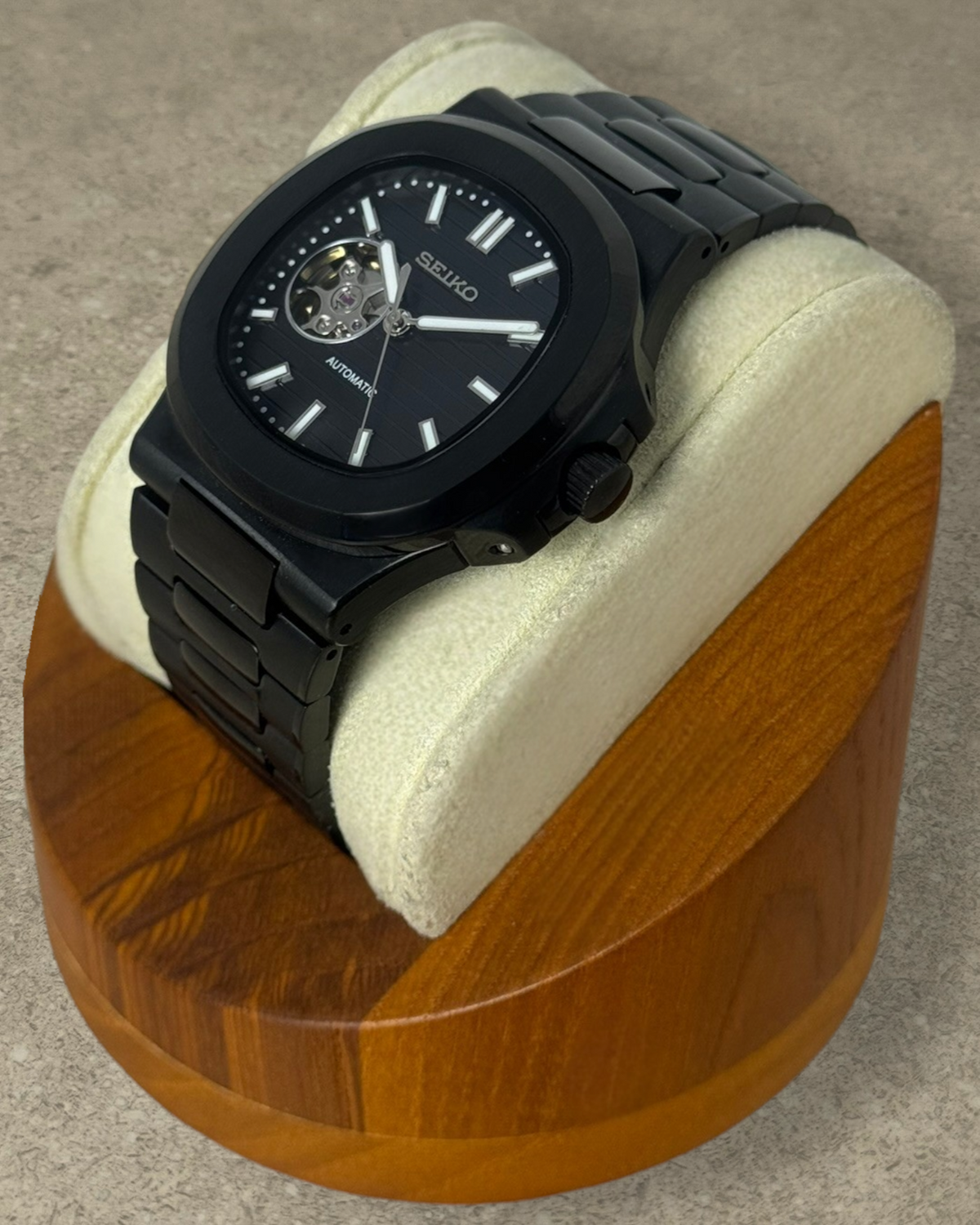 PB TimePiece Novara black stainless steel automatic watch with open heart dial and brushed finish on display stand