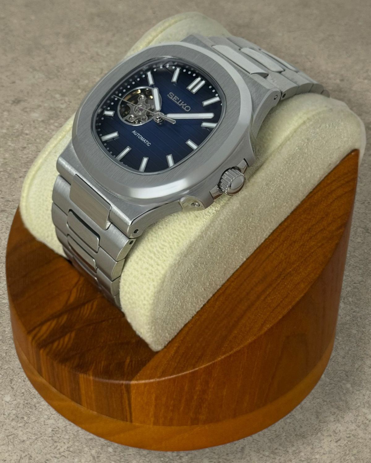 PB TimePiece Novara automatic watch with a blue open heart dial, stainless steel case, and matching bracelet.