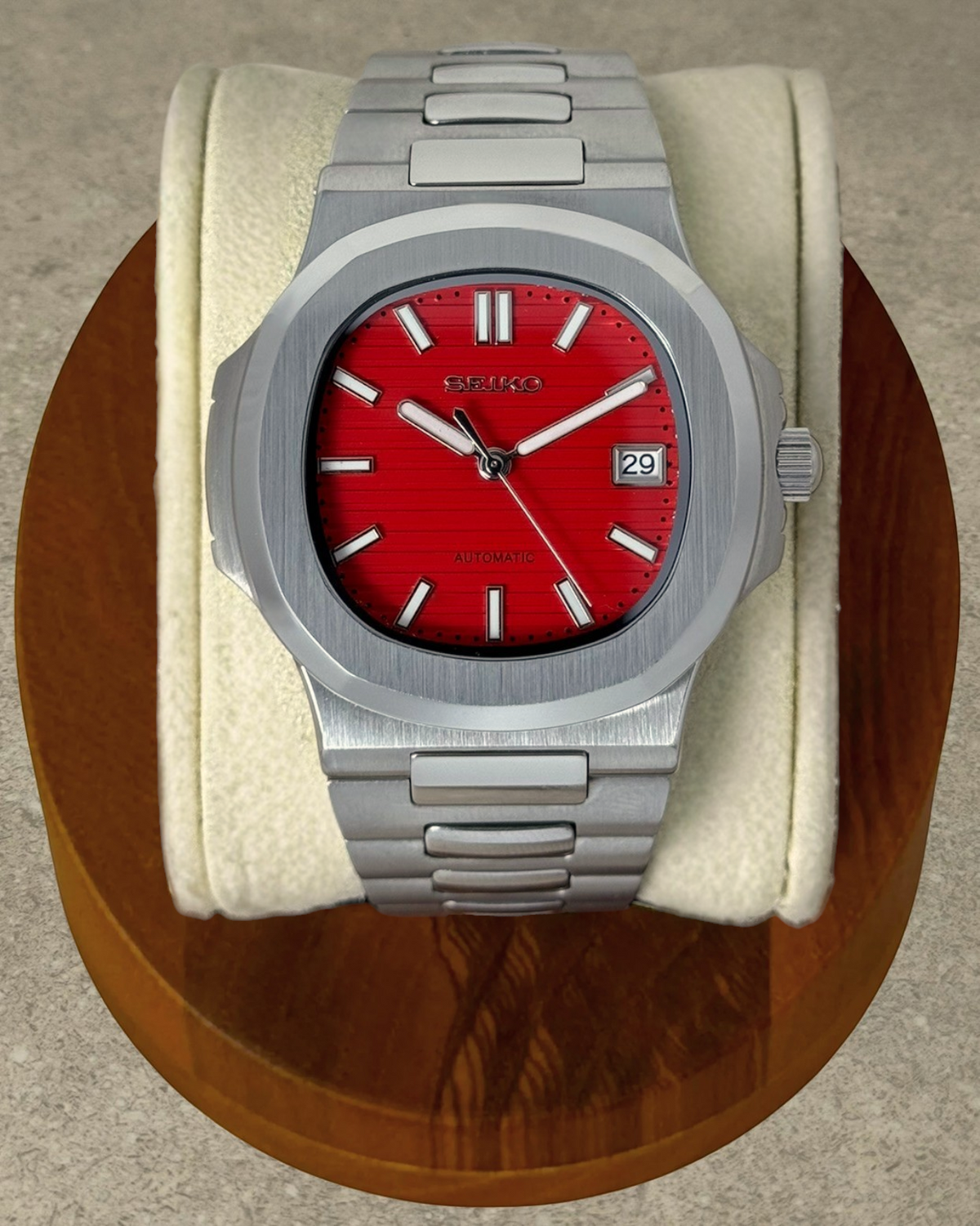 PB TimePiece Novara watch with a textured crimson red dial, stainless steel case, and integrated bracelet.