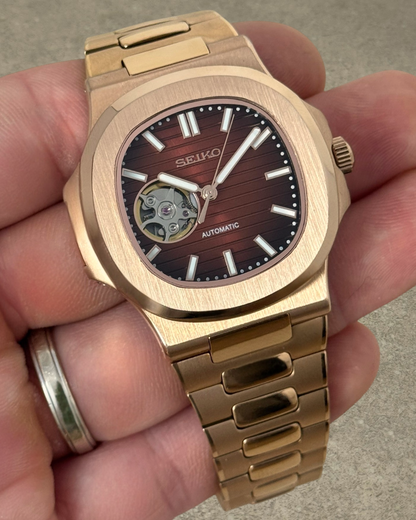 PB TimePiece Novara rose gold automatic watch with an open heart chocolate dial and stainless steel bracelet.