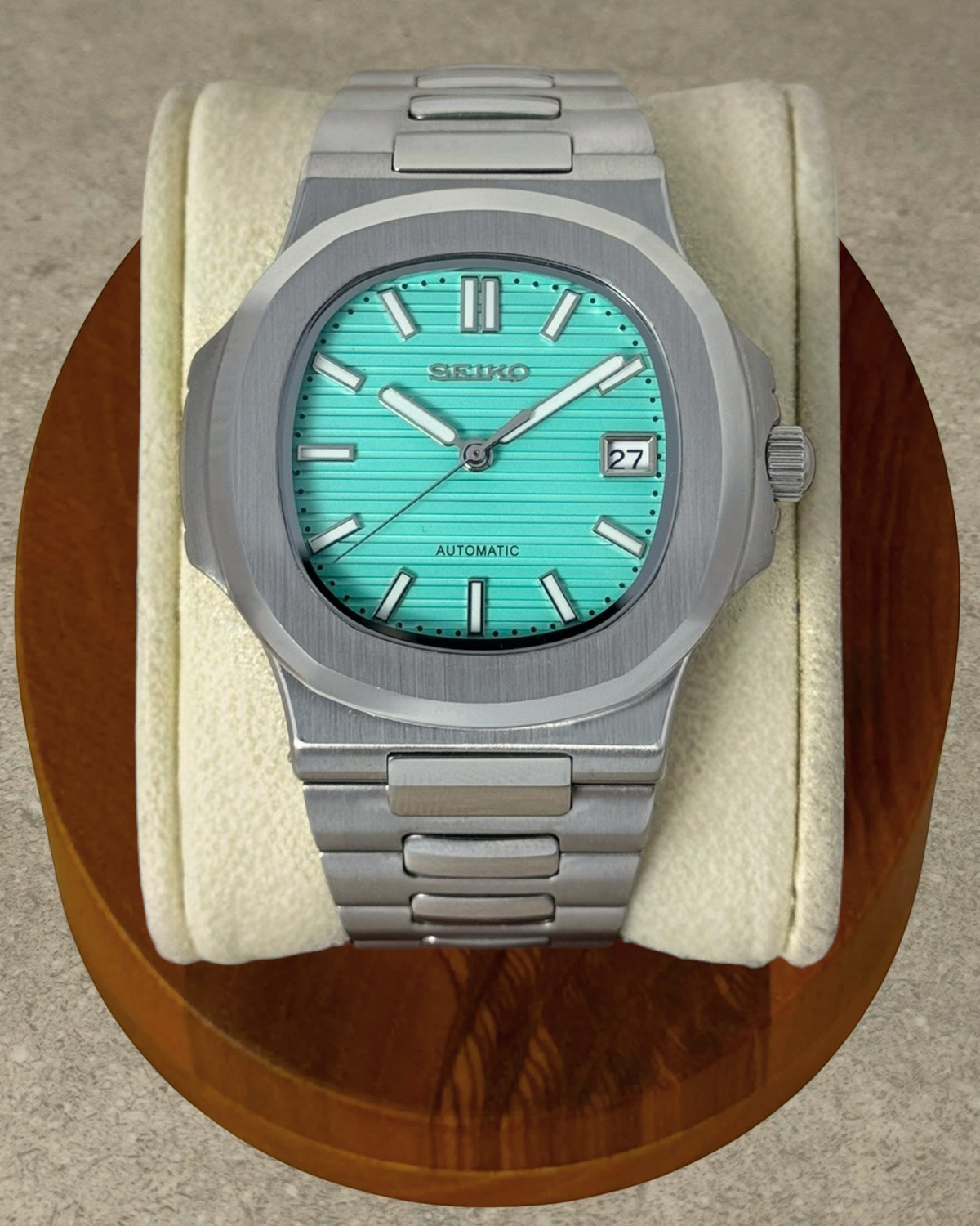 PB TimePiece Novara automatic watch with a textured teal blue dial, stainless steel case, and bracelet.