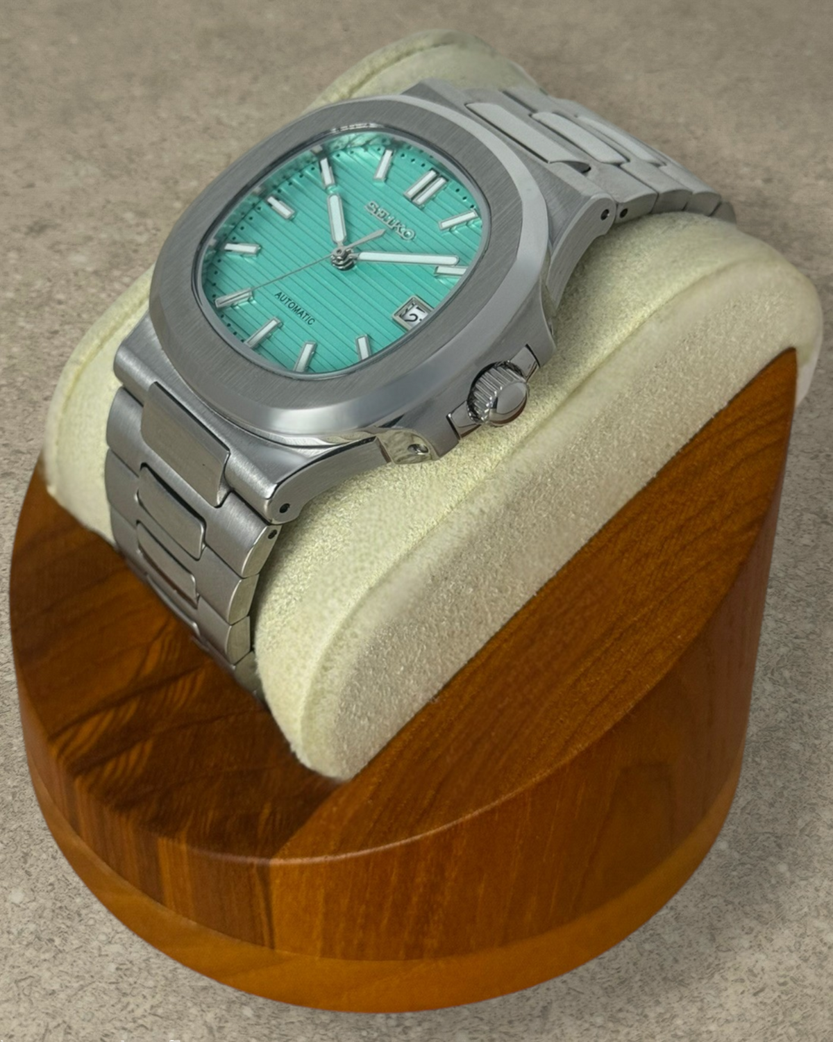 PB TimePiece Novara automatic watch with a textured teal blue dial, stainless steel case, and bracelet.