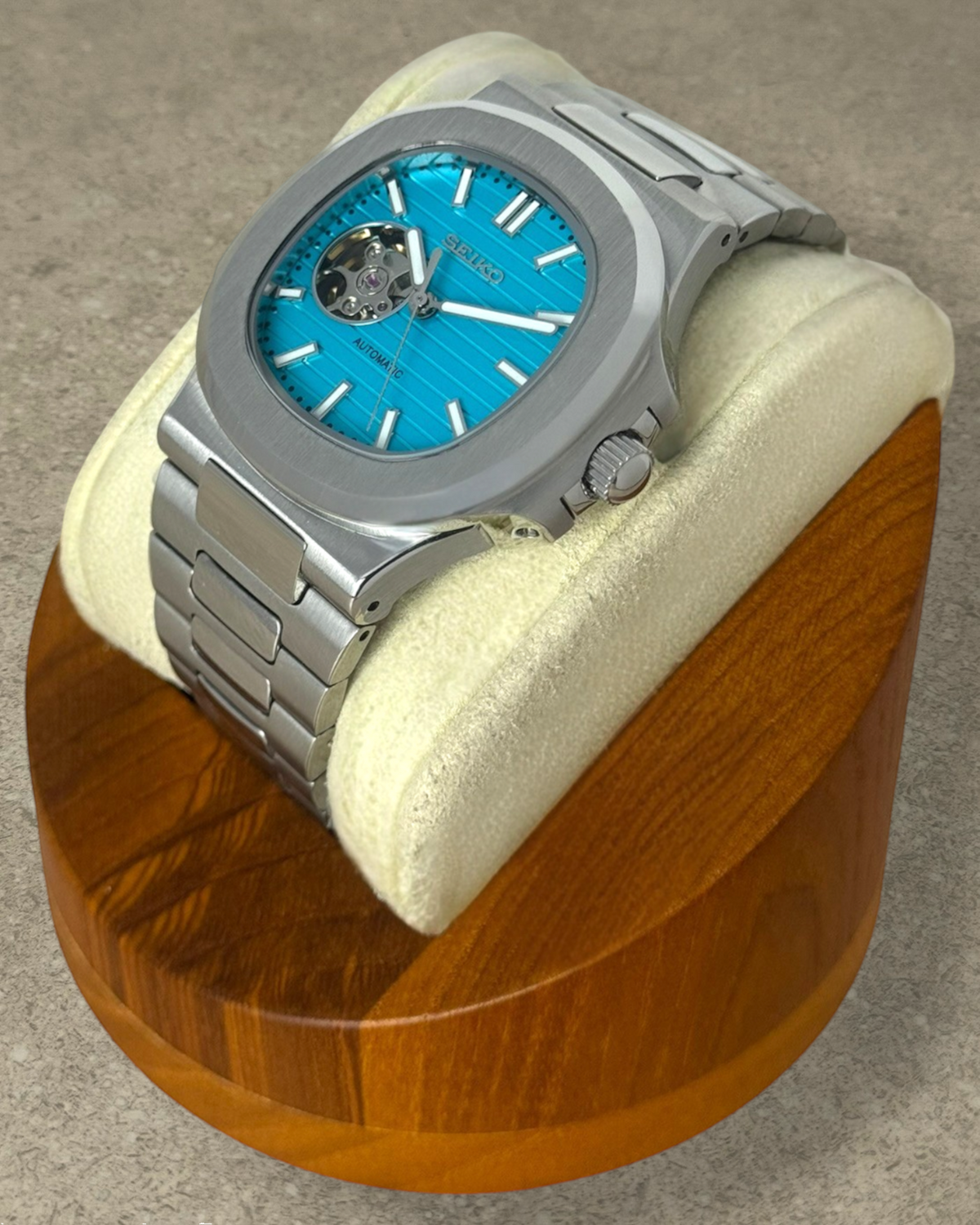 PB TimePiece Novara automatic watch with a teal open heart dial, stainless steel case, and brushed link bracelet.