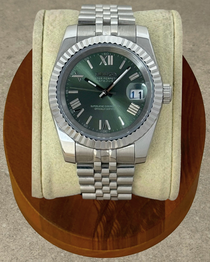 PB TimePiece olive green dial watch with a fluted bezel, stainless steel jubilee bracelet, and Roman numeral markers.