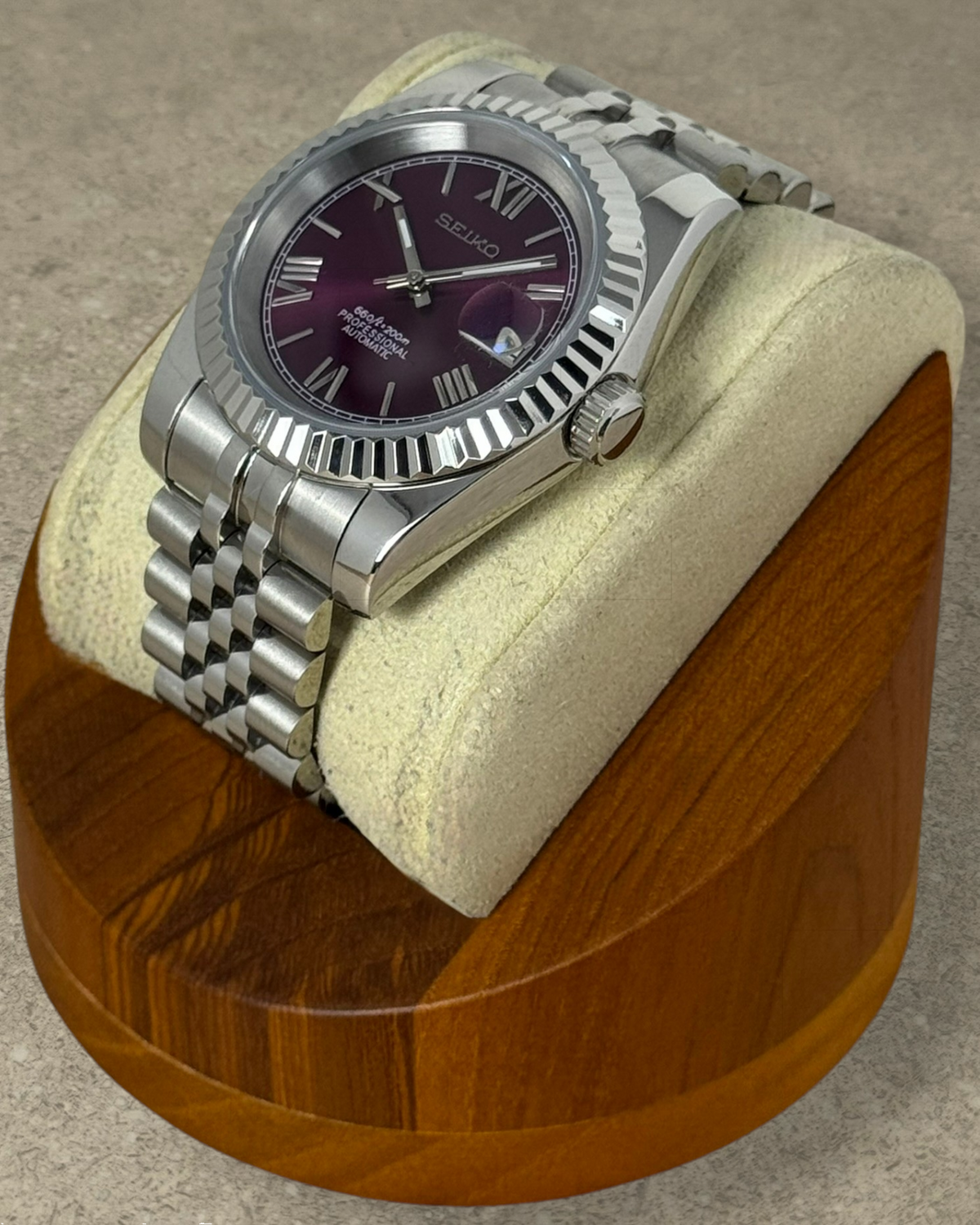 PB TimePiece Classic Date watch with a purple dial, Roman numerals, fluted bezel, and stainless steel jubilee bracelet